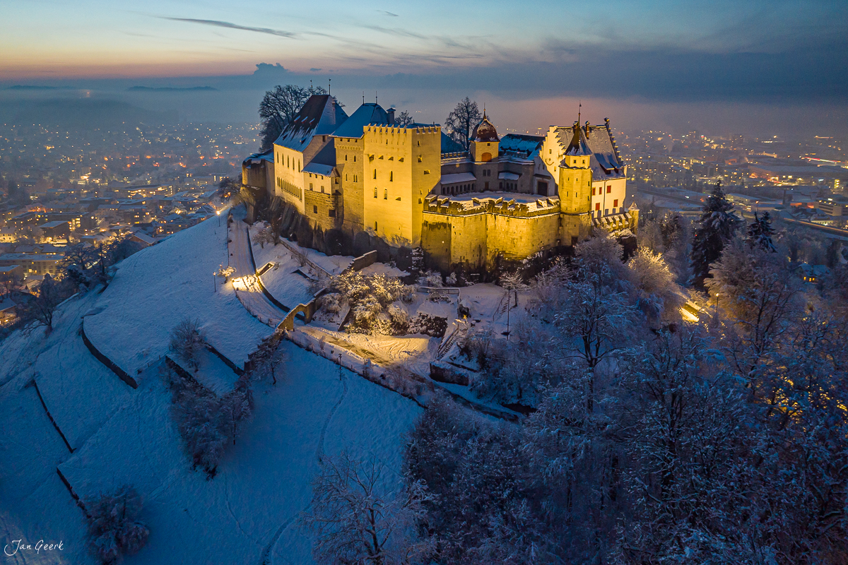 Schloss Lenzburg im Schnee bei Abenddämmerung, aerial Drohnenaufnahme, Winter Kantlicht, Aargau Schweiz – Jan Geerk Fotograf Basel