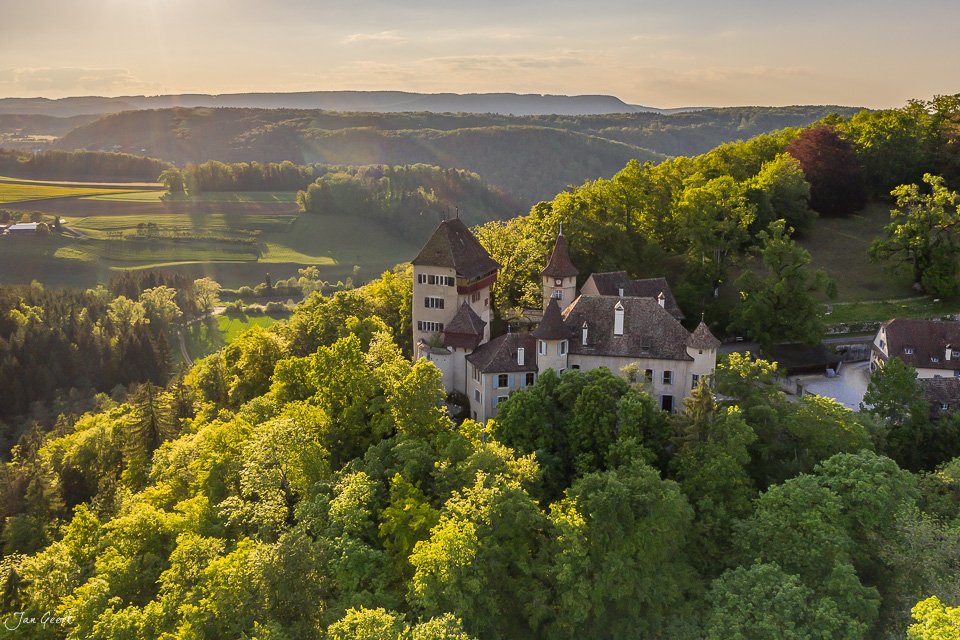 Schloss Wildenstein auf bewaldeter Anhöhe mit Tal im Hintergrund, Frühjahrslight, Baselland Schweiz – Jan Geerk Fotograf Basel