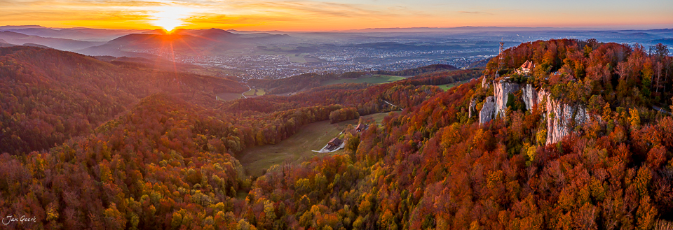 Sonnenaufgang über herbstlicher Waldlandschaft mit Felsklippen in der Schweiz – Jan Geerk Fotograf Basel