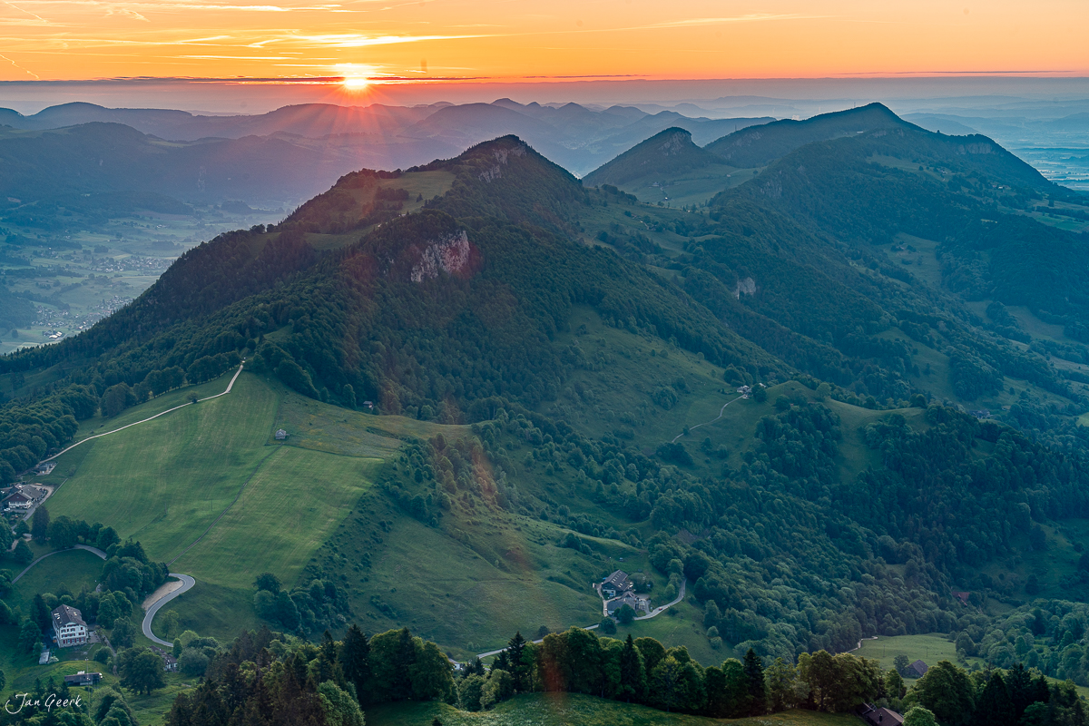 Sonnenaufgang über dem Weissenstein mit grünen Juraweiden und Bergketten in der Schweiz – Jan Geerk Fotograf Basel
