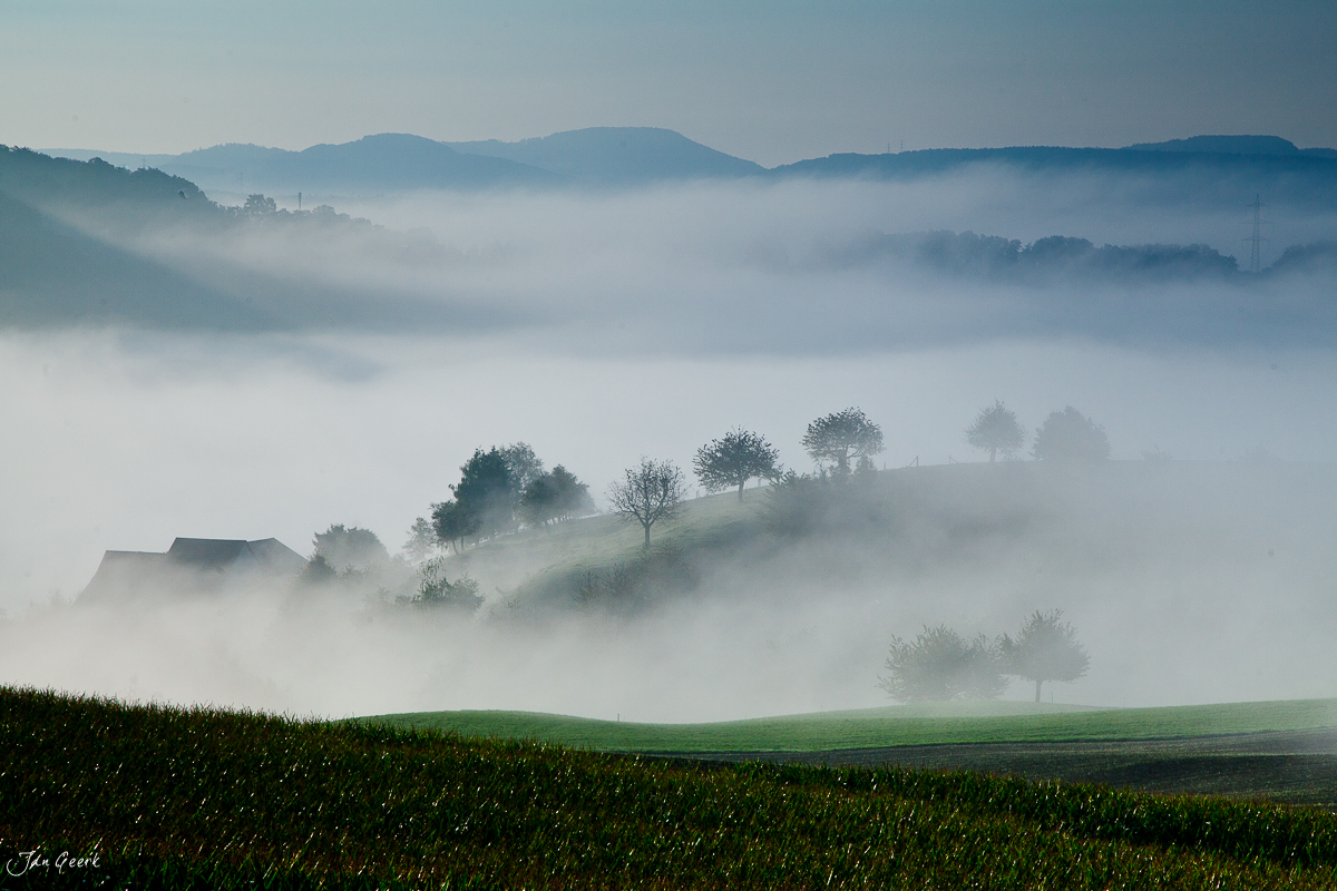 Nebellandschaft Baselland Sonnenaufgang mit Bauernhof und Bäumen Schweiz Jan Geerk Fotograf Basel