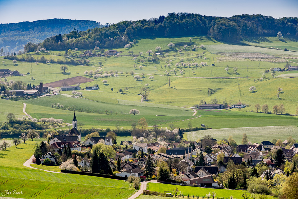 Dorfkirche Arisdorf mit Frühjahrslandschaft und Kirschblütenbäumen im Fricktal Baselland Schweiz – Jan Geerk Fotograf Basel