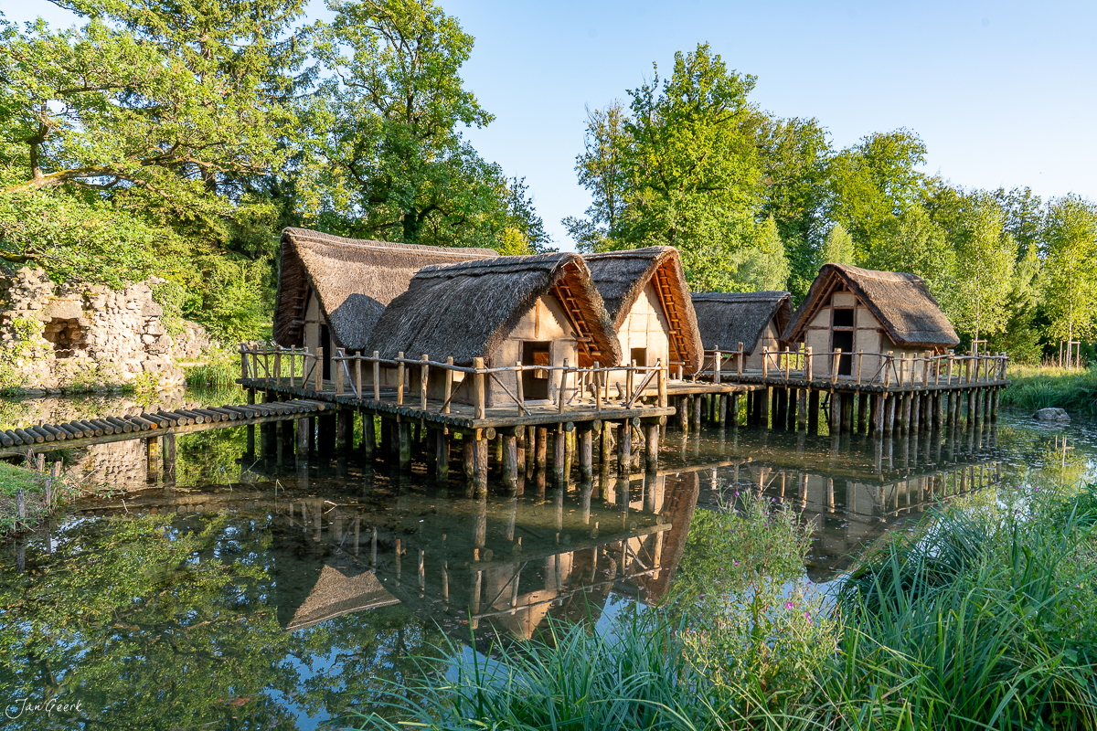 Rekonstruierte Pfahlbauten am Wasser in Schönenwerd mit Strohdächern, grüne Bäume, sonnige Sommeratmosphäre, Solothurn Schweiz – Jan Geerk Fotograf Basel