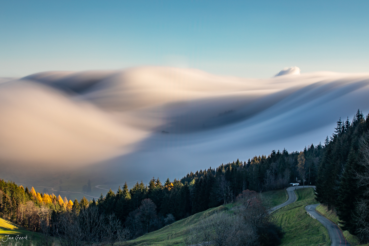 Nebelwelle über dem Bölchen mit Herbstlicht, grüne Wiesen und Wald, Baselbiet Schweiz – Jan Geerk Fotograf Basel