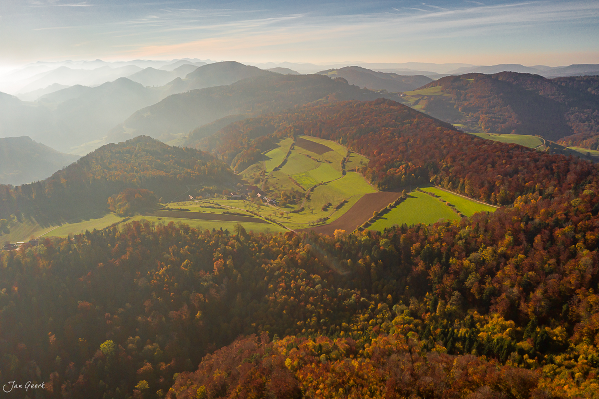 Herbstliche Berglandschaft mit Waldbergen und Ackerflächen im Herbstlicht, Nordwestschweiz – Jan Geerk Fotograf Basel