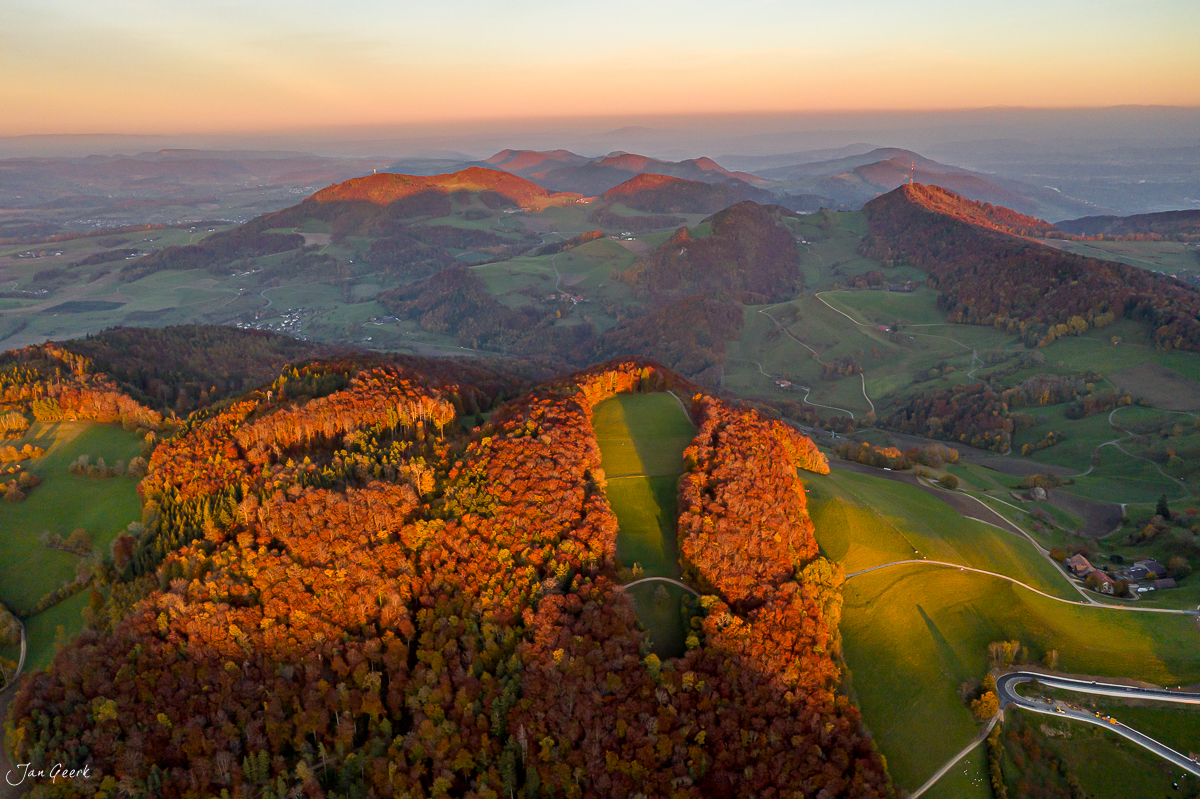 Herbstliche Waldlandschaft mit Herbstfärbung, goldene Morgenlichtstimmung über sanfte Hügel der Schweiz – Jan Geerk Fotograf Basel