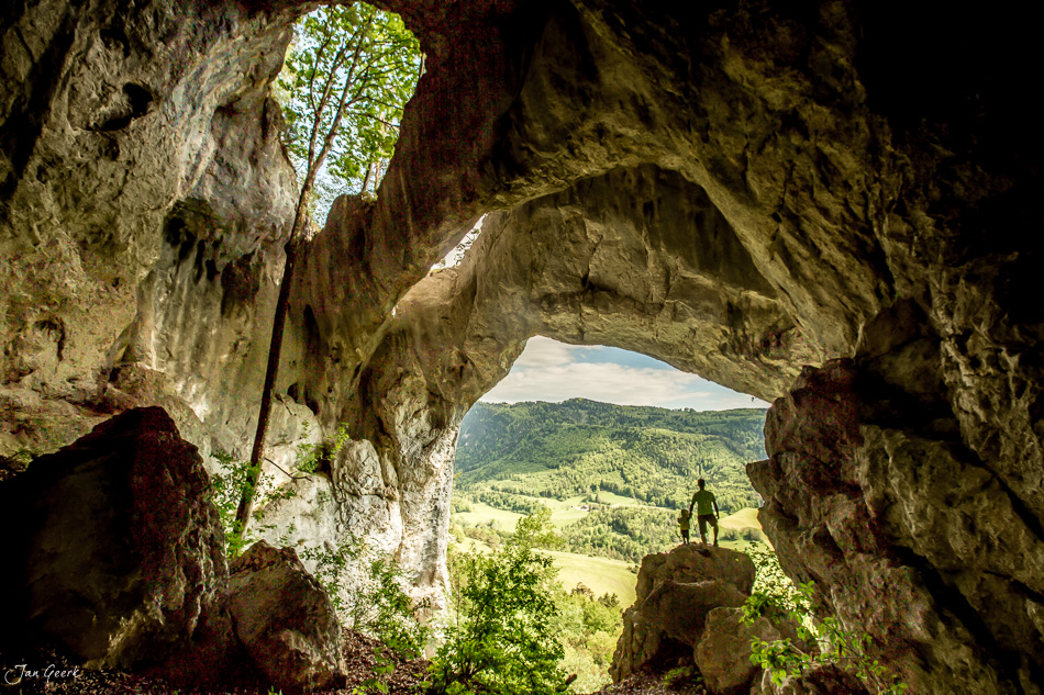 Wolfsschlucht Höhle mit Ausblick auf grüne Jura-Landschaft im Frühling, Welschenrohr Schweiz – Jan Geerk Fotograf Basel