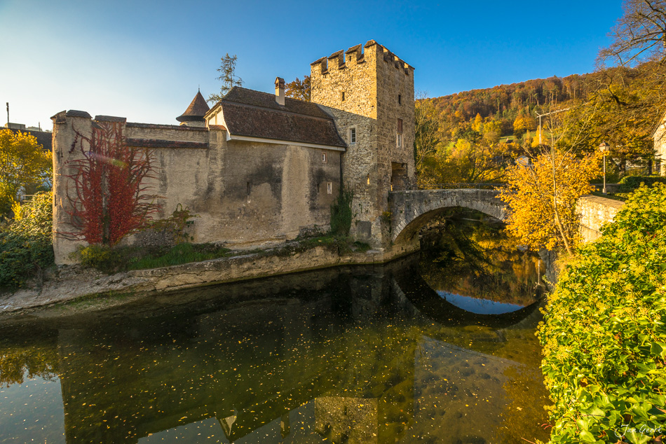 Mittelalterliche Burganlage Zwingen mit Steinbrücke über Fluss, goldenes Herbstlicht, Jura Schweiz – Jan Geerk Fotograf Basel