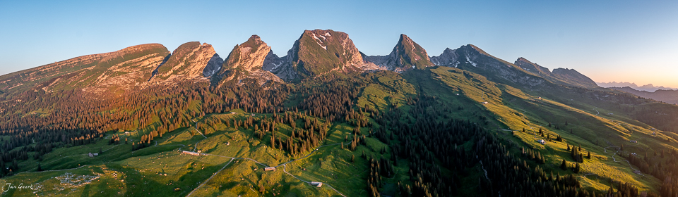 Luftaufnahme der Sellamatt mit herbstlich gefärbten Alpweiden, Fichten und markanten Berggipfeln im Toggenburg der Ostschweiz – Jan Geerk Fotograf Basel