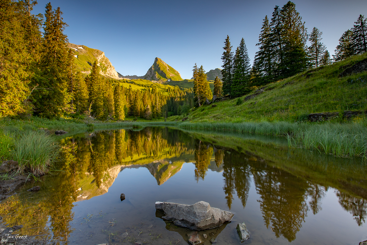 Spiegelglatter Bergsee in der Sellamatt mit Alpengipfeln und Lärchenwäldern im Sommerlicht – Schweiz – Jan Geerk Fotograf Basel