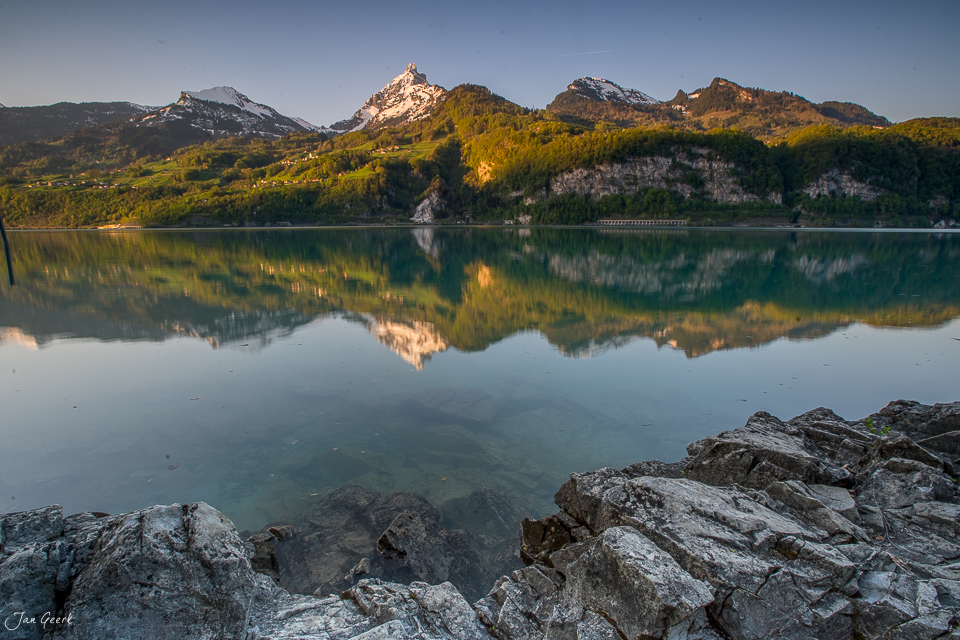 Spiegelung von Bergen und Wald im klaren Walensee Frühling Ostschweiz Schweiz – Jan Geerk Fotograf Basel