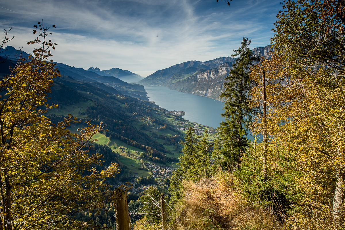 Herbstliche Bergsee-Landschaft Flumserberg mit golden gefärbten Laubbäumen, tiefblauem See und dramatischen Bergketten in der Ostschweiz – Jan Geerk Fotograf Basel