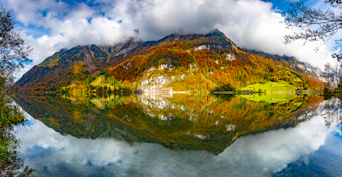 Klöntalersee mit herbstlichen Lärchen und Bergspiegelung in klarem Wasser, Glarus Schweiz – Jan Geerk Fotograf Basel