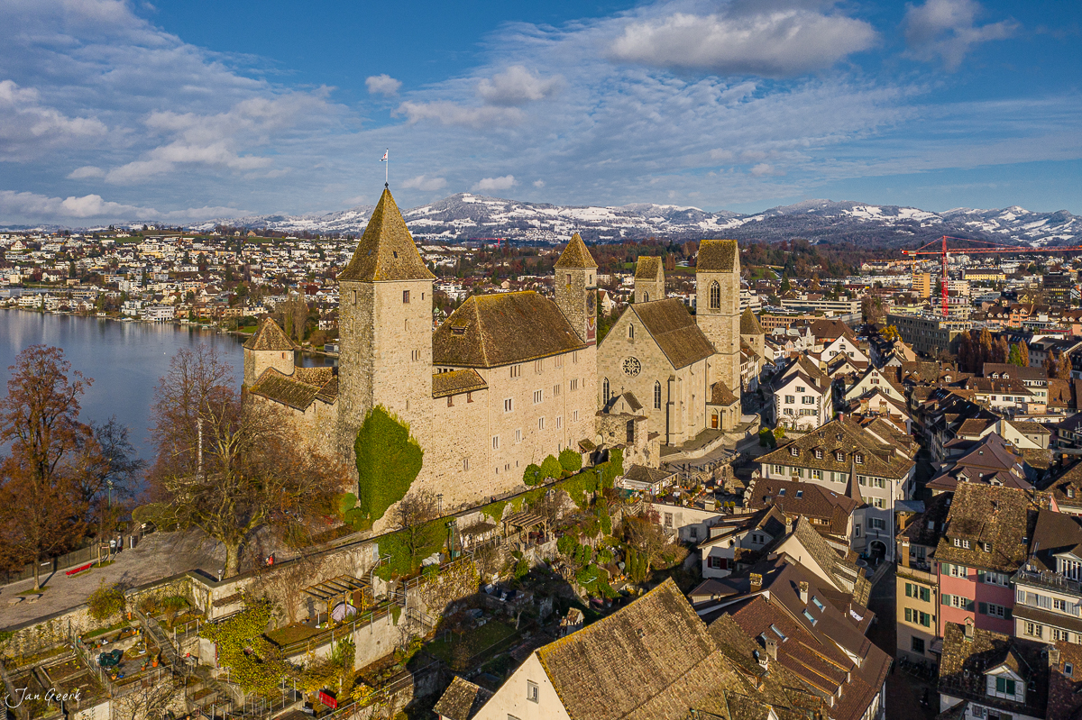 Rapperswil Schloss mit Türmen am See, schneebedeckte Alpen im Hintergrund, Frühling, Ostschweiz – Jan Geerk Fotograf Basel
