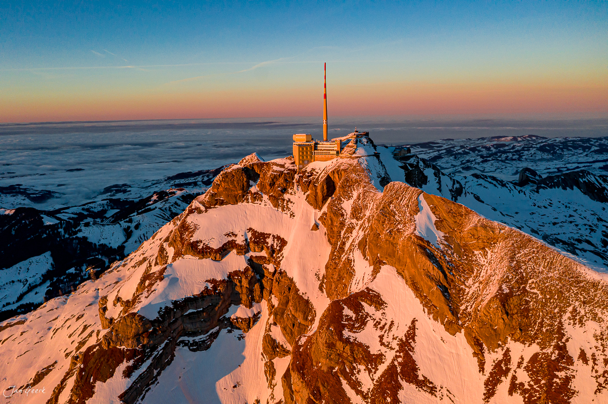 Säntis Gipfel mit Sendeturm im Sonnenuntergang, verschneite Berglandschaft, Luftaufnahme der Appenzeller Alpen Schweiz – Jan Geerk Fotograf Basel