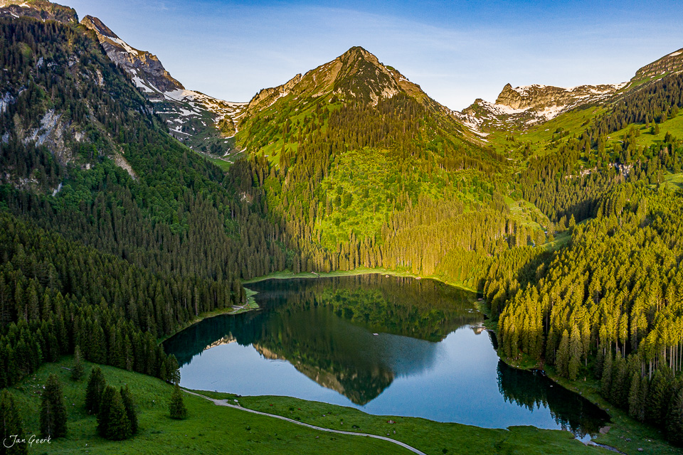 Alpensee Voralpsee von oben im Sommer, umgeben von Fichten und Bergspitzen, Schweiz – Jan Geerk Fotograf Basel