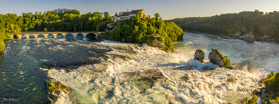 Luftaufnahme Rheinfall mit Schloss Laufen, Brücke und Flusslandschaft bei Sonnenlicht, Schaffhausen Ostschweiz – Jan Geerk Fotograf Basel