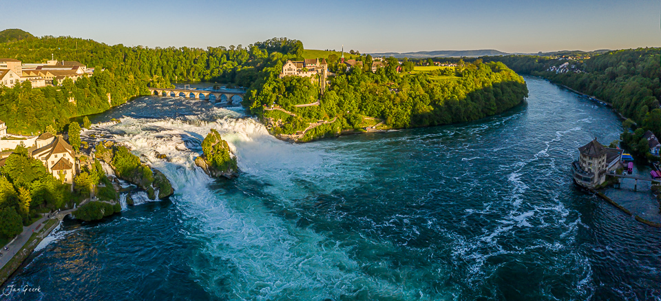 Luftaufnahme des Rheinfalls bei Schaffhausen mit grünem Uferwald und blauem Wasser im Sommerlicht Schweiz Jan Geerk Fotograf Basel