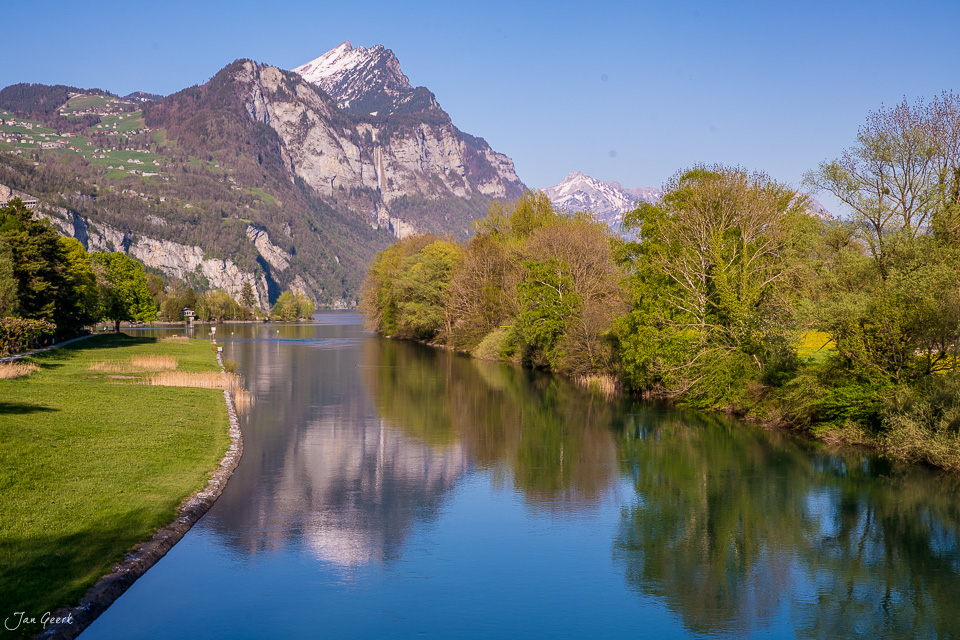 Walensee mit Spiegelungen, umgeben von grünen Wiesen und Bäumen im Frühling, Ostschweiz – Jan Geerk Fotograf Basel