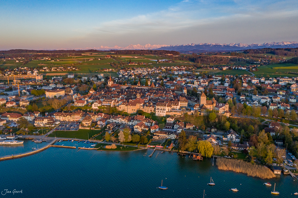 Luftaufnahme von Murten mit Murtensee, Altstadt und Alpen im Frühlingslicht – Schweiz, Jan Geerk Fotograf Basel