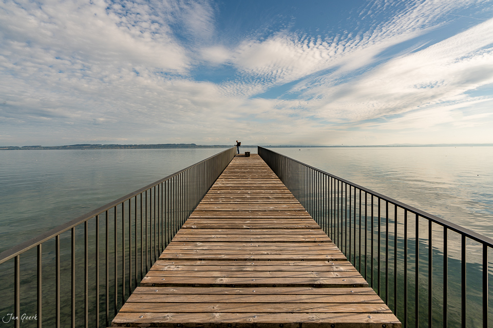 Holzsteg am Neuenburgersee mit ruhigem Wasser und blauem Himmel, Herbststimmung, Seeland Schweiz – Jan Geerk Fotograf Basel