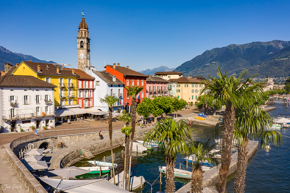 Ascona Hafen mit bunten Häusern, Kirchturm und Palmen am Lago Maggiore, Sommerlichtstimmung, Tessin, Schweiz – Jan Geerk Fotograf Basel