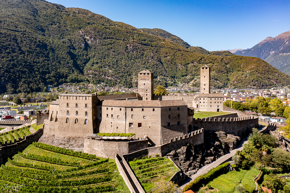 Mittelalterliche Burganlage Bellinzona mit zwei Türmen, grüne Weinberge, Sommer, Tessin Schweiz – Jan Geerk Fotograf Basel