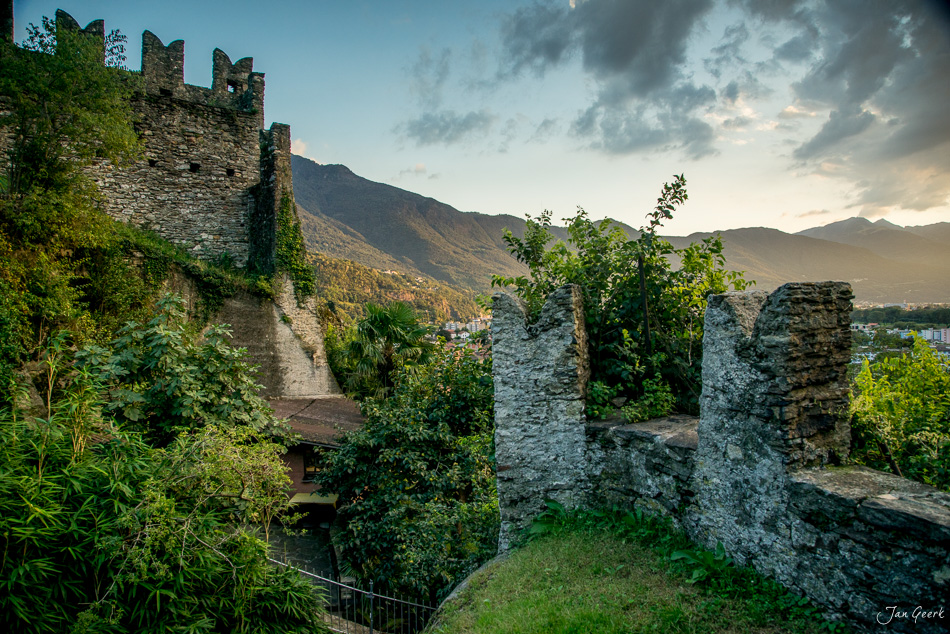 Mittelalterliche Burgruine Castelgrande mit Zinnen und Mauerwerk, umgeben von grüner Vegetation in sommerlicher Lichtstimmung, Tessin Schweiz – Jan Geerk Fotograf Basel