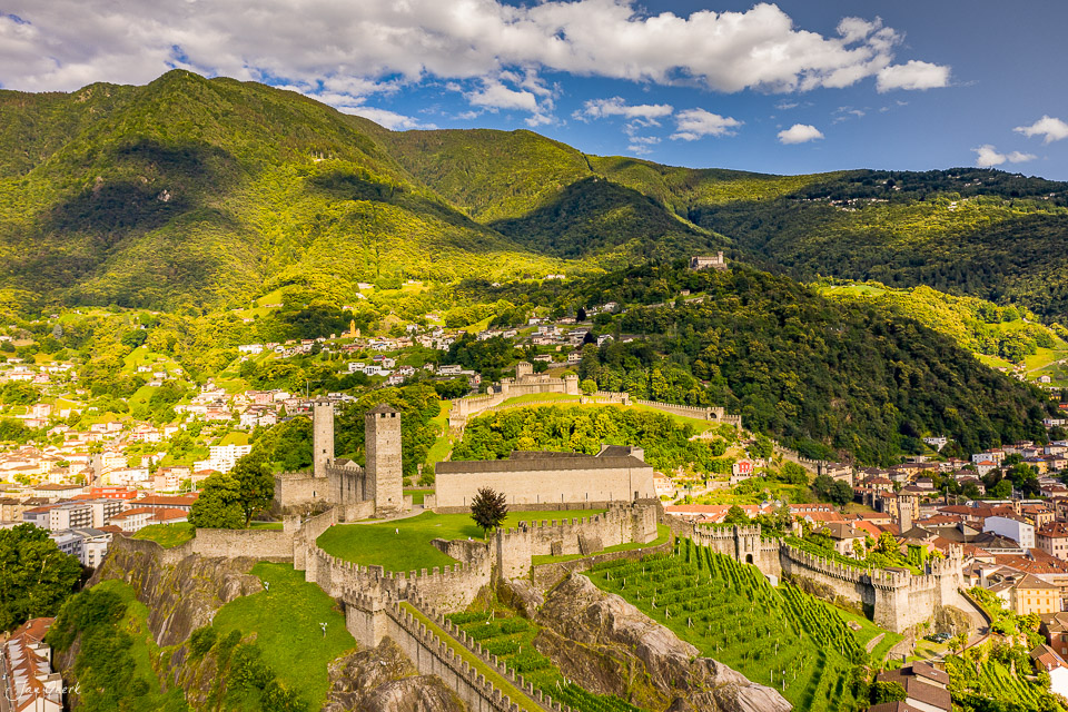 Luftaufnahme der mittelalterlichen Burgen und Stadt Bellinzona im Sommer, umgeben von grünen Bergen im Tessin Schweiz – Jan Geerk Fotograf Basel