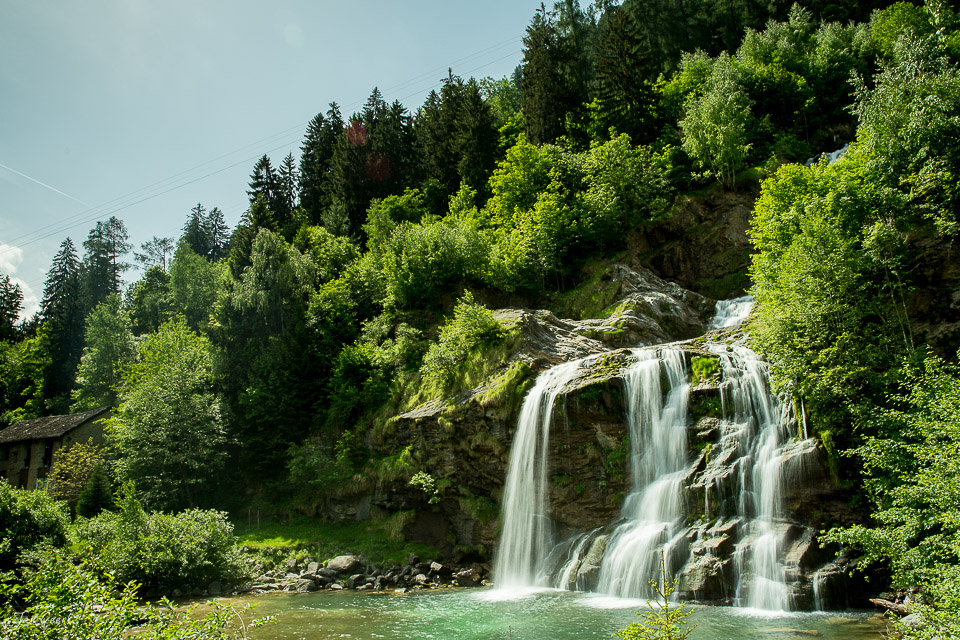 Wasserfall in Faido umgeben von dichtem Grünwald, Sommerlichtstimmung in den Tessiner Alpen, Schweiz – Jan Geerk Fotograf Basel
