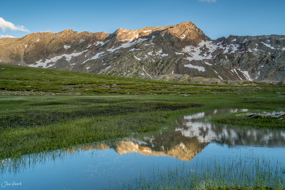Alpensee mit Spiegelung und schneebedeckten Bergen bei Lajozz, Sommermorgen im Tessin, Schweiz – Jan Geerk Fotograf Basel