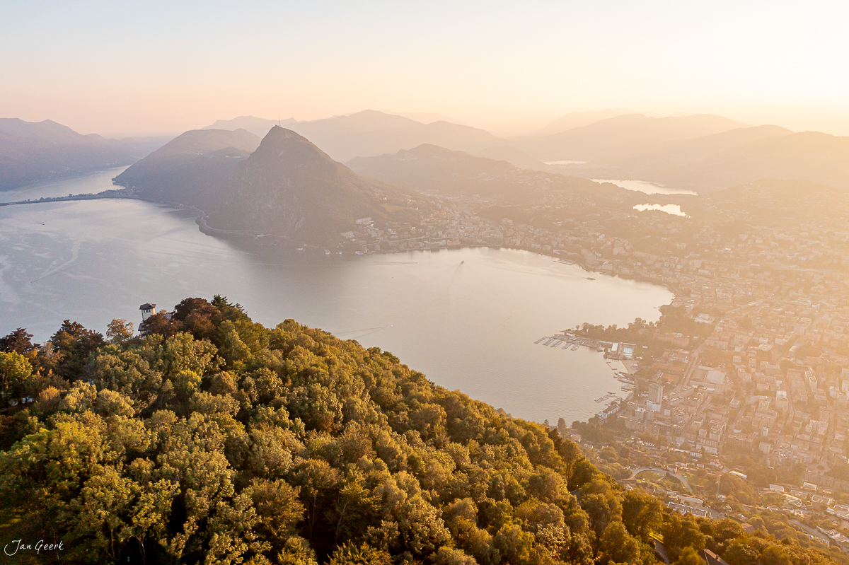 Luftaufnahme Lugano mit Monte San Salvatore, Stadt und Seen in goldener Herbststimmung, Tessin Schweiz – Jan Geerk Fotograf Basel