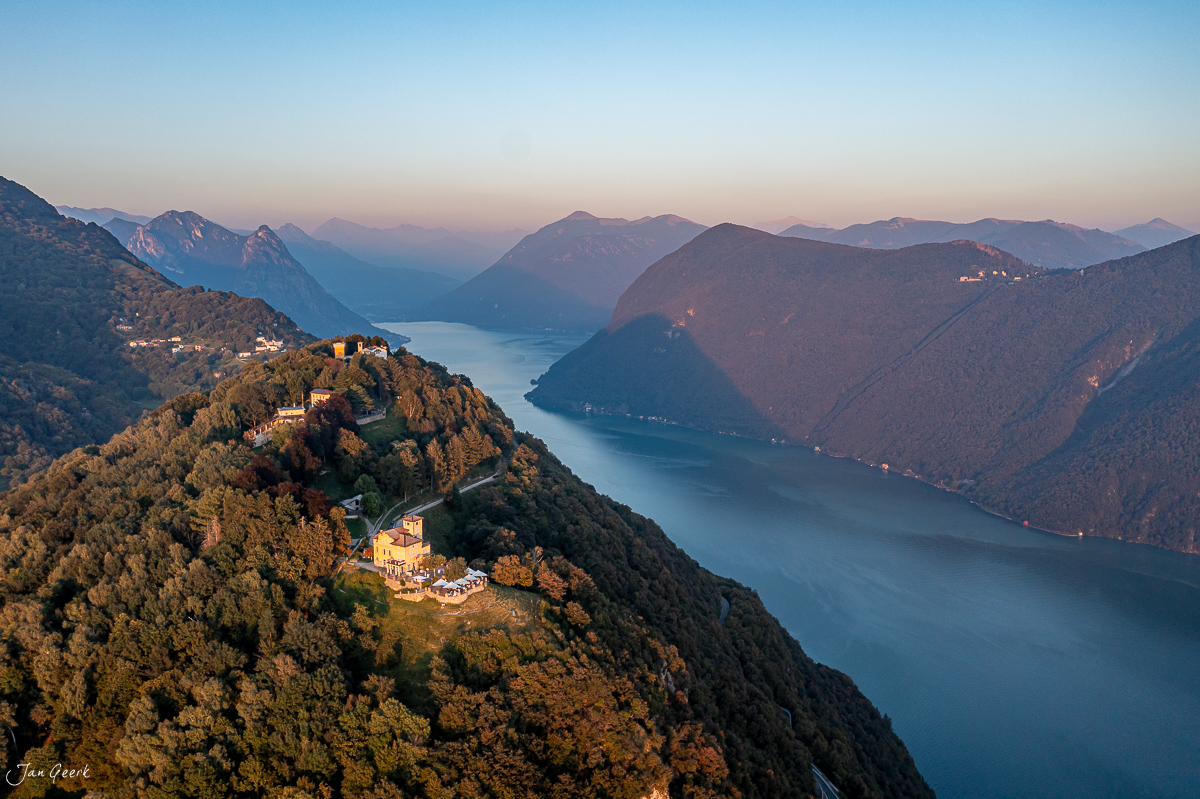 Luftaufnahme Lugano mit See, herbstliche Berglandschaft und Kirche, Tessin Schweiz – Jan Geerk Fotograf Basel