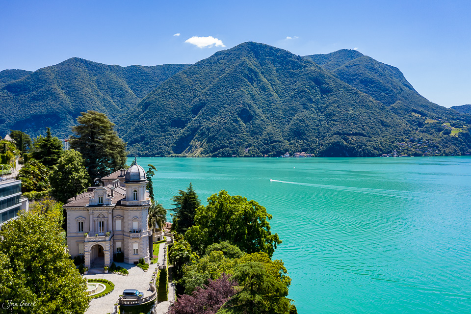 Luftaufnahme Lugano mit Kirche, türkisblauem See und bewaldeten Bergen im Sommer, Tessin Schweiz – Jan Geerk Fotograf Basel