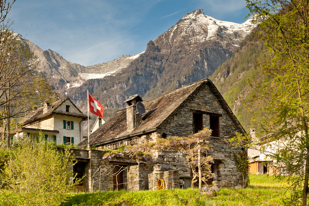 Verzasca Rustico Steinhaus Schweizer Fahne Bergpanorama Schnee Tessin Schweiz – Jan Geerk Fotograf Basel
