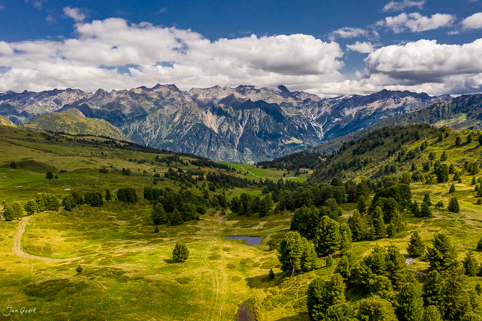 Luftaufnahme Alpenlandschaft Lukmanierpass mit grünen Wiesen, Fichtenwäldern und Bergpanorama im Sommer, Tessin Schweiz – Jan Geerk Fotograf Basel