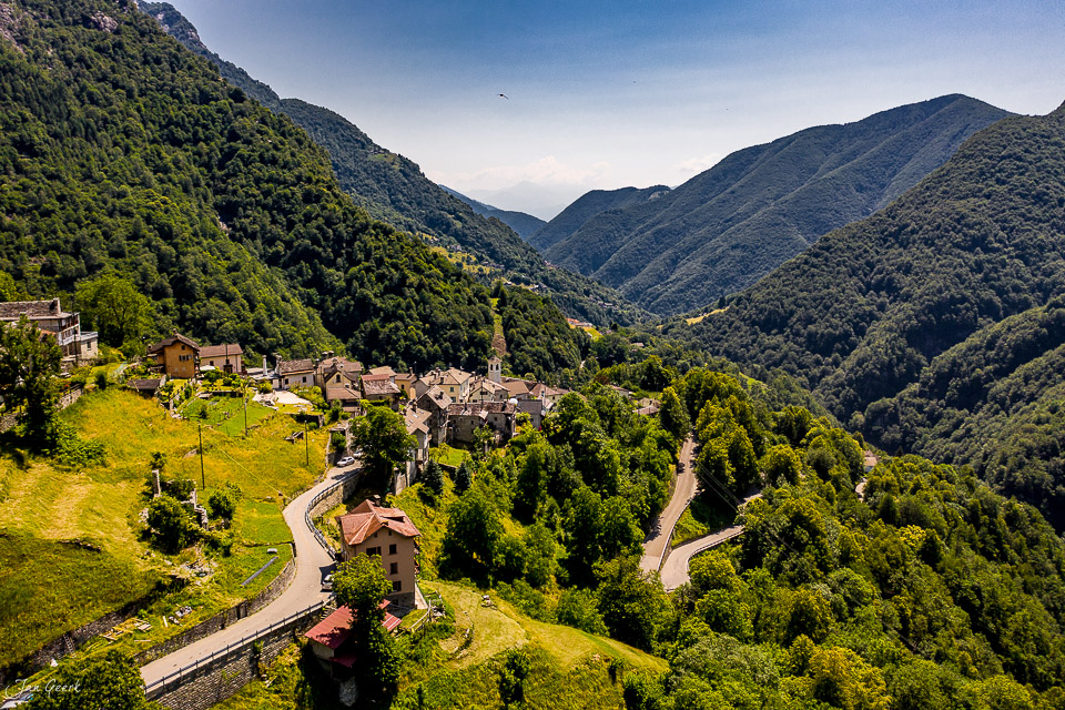 Luftaufnahme des malerischen Onsernonetal mit grünen Bergen und traditionellen Häusern im Sommer, Tessin Schweiz – Jan Geerk Fotograf Basel