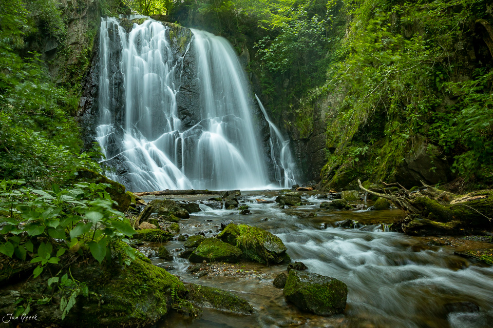 Spektakulärer Wasserfall in Sessa mit türkisfarbenem Wasser, umgeben von dichtem grünem Wald und moosigen Felsen im Tessin, Schweiz – Jan Geerk Fotograf Basel