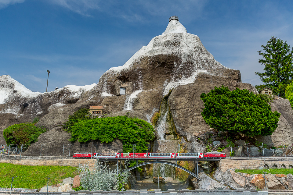 Miniaturmodell Burg auf Felsen in Melide mit rotem Zug, Sommerlicht, Tessin Schweiz – Jan Geerk Fotograf Basel