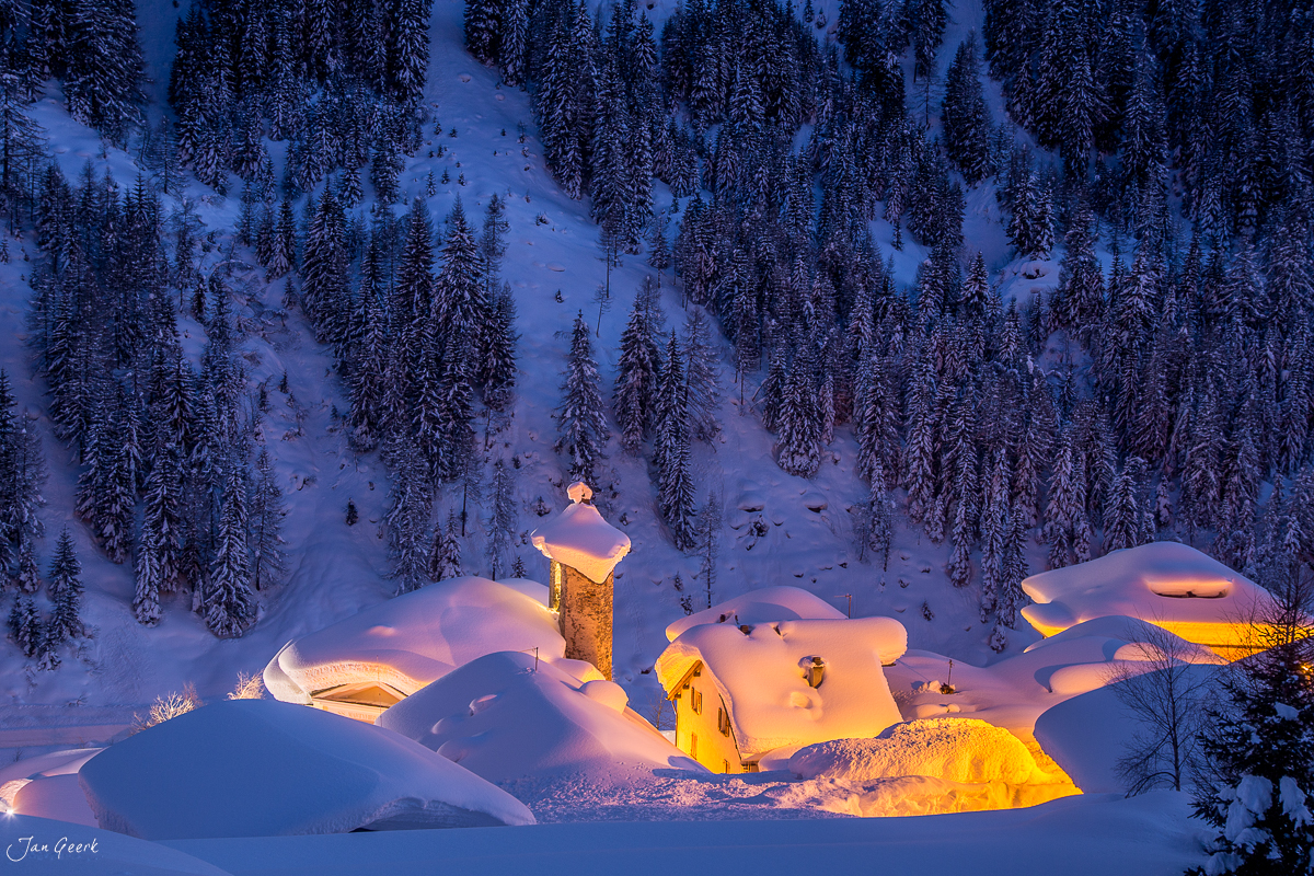 Verschneite Kapelle mit Kirchturm in Bedretto bei Nacht, winterliche Waldlandschaft Tessin Schweiz – Jan Geerk Fotograf Basel