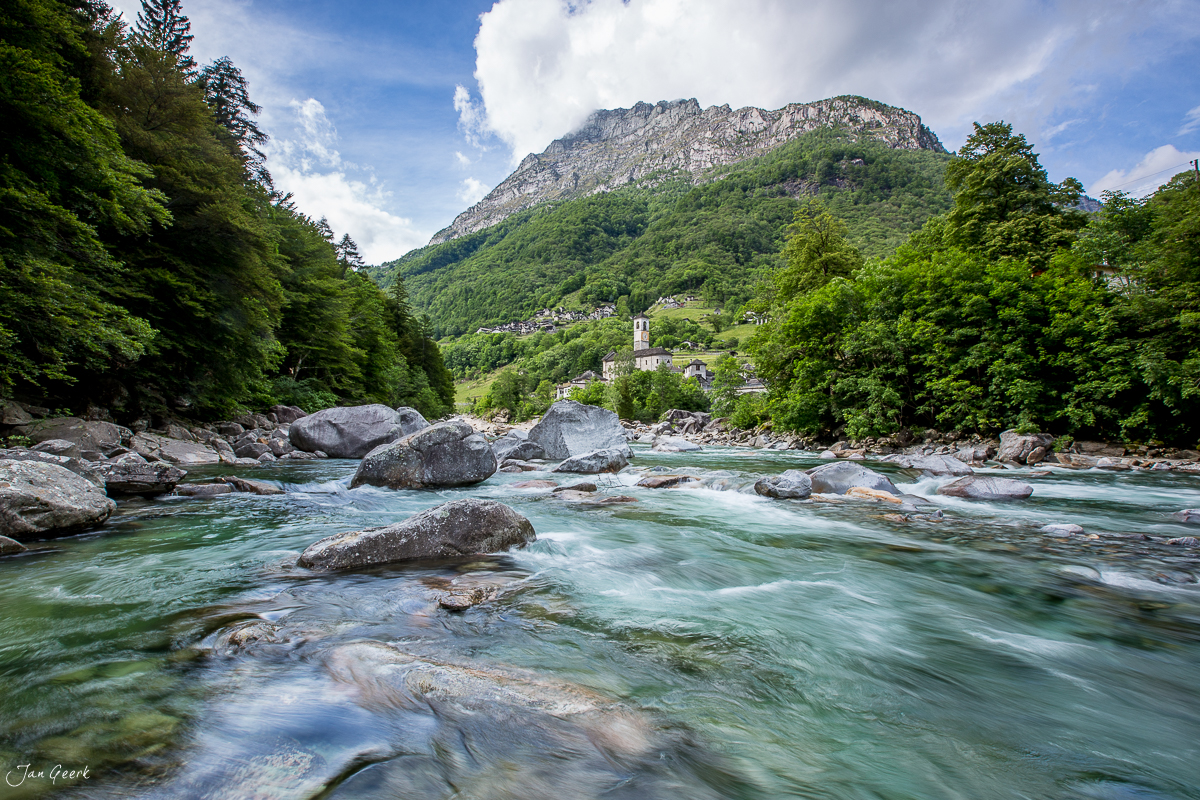 Fluss Geer im Bleniotal mit Felsblöcken, grüner Bergwald und Alpendorf, Frühling, Nordtessin Schweiz – Jan Geerk Fotograf Basel