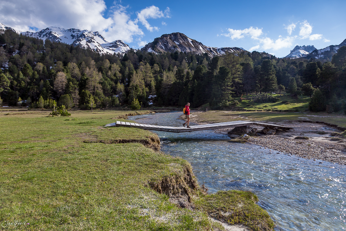 Wanderer an Holzsteg über Bergbach, Casaccia Lukmanierpass Frühling Tessin Schweiz – Jan Geerk Fotograf Basel