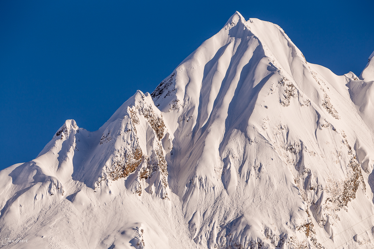 Schneebedeckter Berggipfel im Bedretto mit klarem Himmel, Winterstimmung in den Südalpen, Tessin Schweiz – Jan Geerk Fotograf Basel