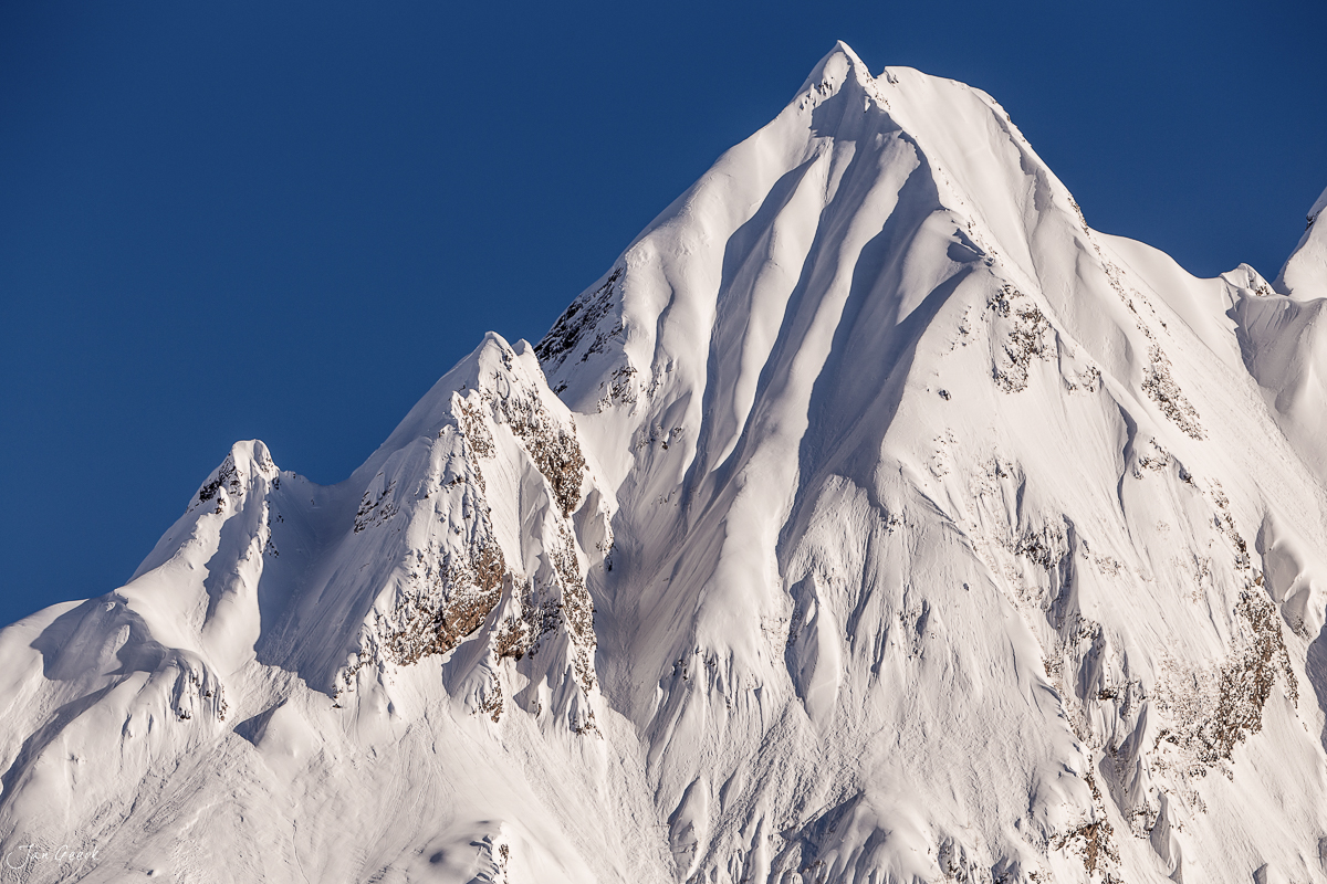 Schneebedeckter Berggipfel in Bedretto mit dramatischen Schneefällen und tiefblauem Himmel, Nordtessin Schweiz – Jan Geerk Fotograf Basel
