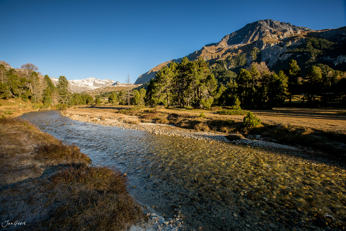 Flusslandschaft im Tessin mit Bergen und Herbstwald unter blauem Himmel Schweiz Jan Geerk Fotograf Basel