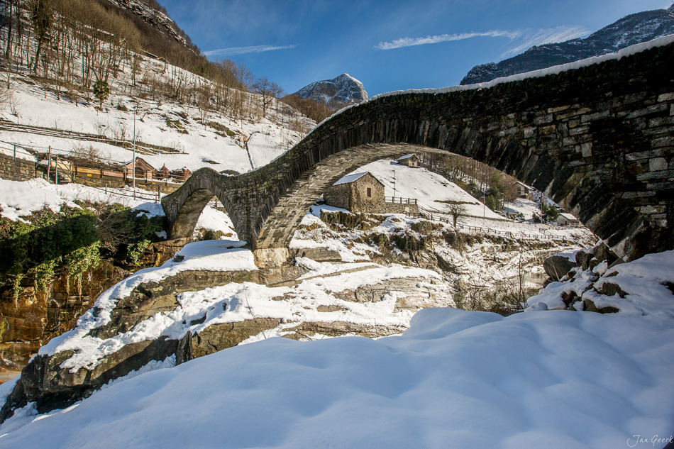 Historische Steinbogenbrücke über verschneiten Fluss in Locarno, Tessin, Winterlandschaft Schweiz – Jan Geerk Fotograf Basel