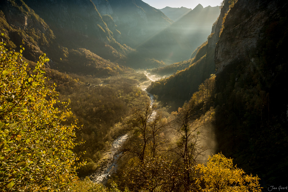 Herbstliches Alpental mit Fluss, Tessin, goldenes Herbstlicht durchflutet die Bergeschlucht, Schweiz – Jan Geerk Fotograf Basel