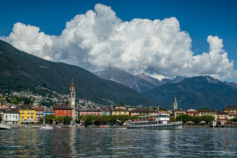 Farbenfrohe Häuser und Kirche am See in Ascona, Sommertag mit dramatischen Wolken, Tessin Schweiz – Jan Geerk Fotograf Basel