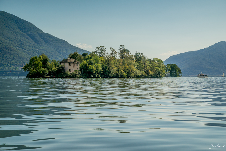 Historisches Steinhaus auf einer bewaldeten Insel im Lago Maggiore bei Locarno, Sommerlichtstimmung, Tessin Schweiz – Jan Geerk Fotograf Basel
