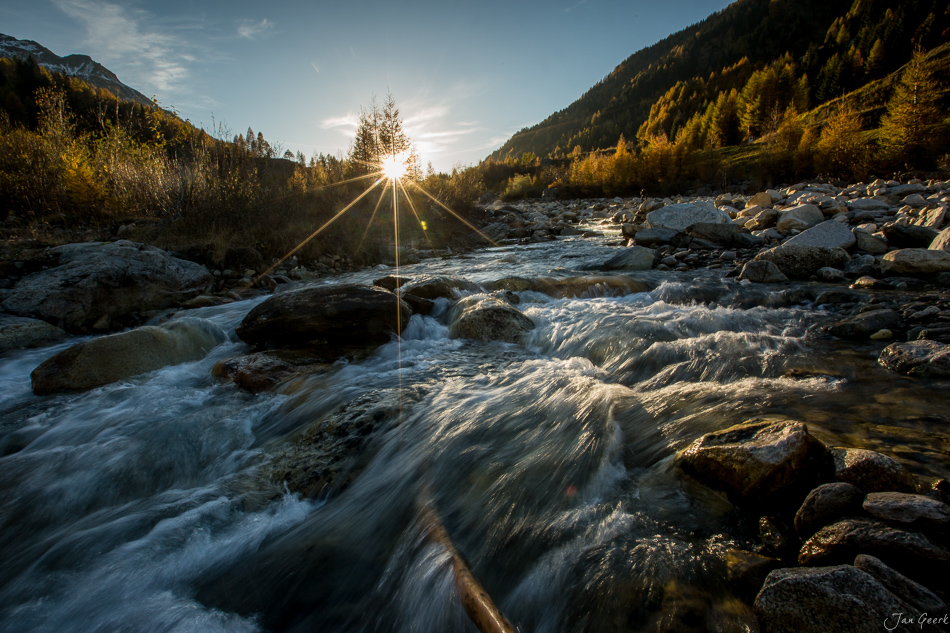 Flusslandschaft Tessin mit Herbstwald, Felsen und Sonnenstrahlen in der Schweiz – Jan Geerk Fotograf Basel